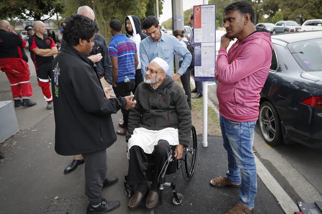 Farid Ahmed, center, a 59-year-old survivor of the Friday mosque attacks, talks with other relatives outside an information center for families, Saturday, March 16, 2019, in Christchurch, New Zealand. (AP Photo/Vincent Thian)
