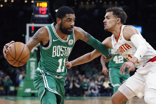 The Celtics' Kyrie Irving, who finished with 30 points, 11 rebounds and nine assists, tries to drive past the Hawks' Trae Young during the first half of Saturday's game. [AP / Michael Dwyer]