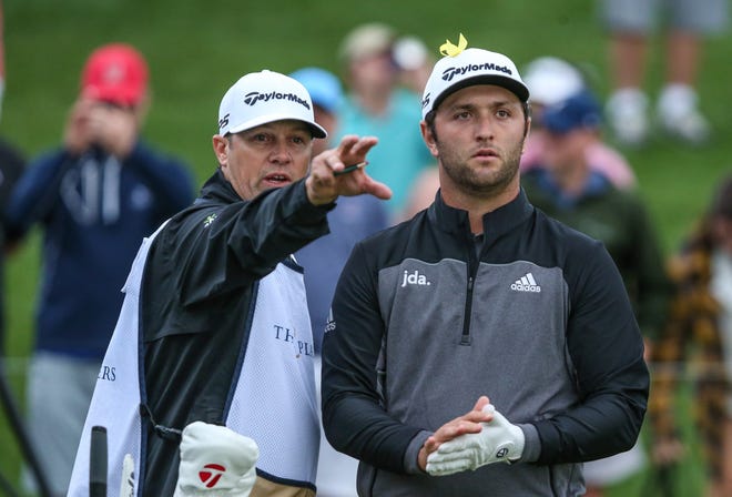 Jon Rahm, right, and his caddy Adam Hayes look down the 18th fairway from the tee before his drive during Saturday's third round of The Players Championship. [Gary Lloyd McCullough/GateHouse Florida]