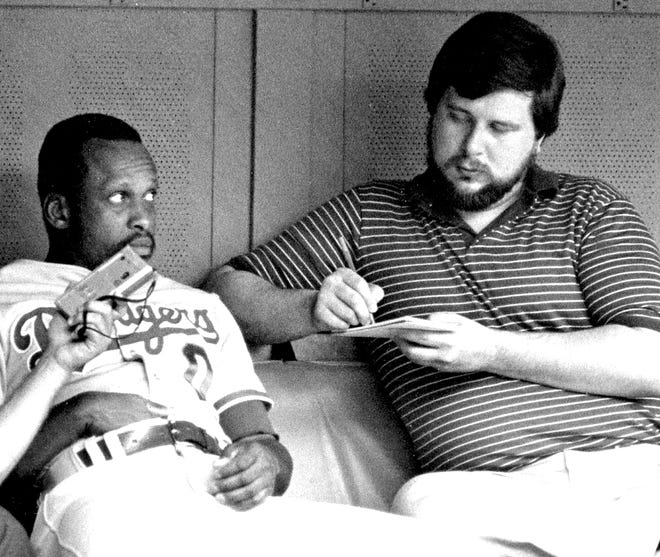 Former Beaver County Times sportswriter John Mehno chats with former Pirate Al Oliver, then a Dodger, in the dugout at Three Rivers Stadium in 1985. [BCT File]