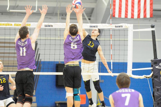 Siena Heights sophomore outside hitter Alex Garavalia (13) drives a kill against Goshen’s Andy Bennett (11) and Michael Wahl at the SHU Tournament on Saturday morning.
