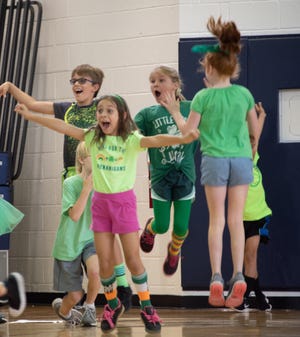 Team Green members, back row, Ajax LaNasa (4th grade) and Caroline Mischke (3rd grade) and front row, Sabrina Quattrocchi (2nd grade) and McKenna Boysan (4th Grade) jump for joy after winning Rosarian's lower school Field Day. [Courtesy of Rosarian Academy]