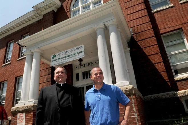 Father Gary Belliveau, left, pastor of Corpus Christi Parish, and Jim Broom, founder of the Hope for Tomorrow Foundation, stand in front of St. Patrick School’s former building on Austin Street in May 2016. Belliveau announced the old school building will be razed to make room for Immaculate Conception Church parking. [Deb Cram/Seacoastonline, file]