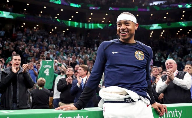 Denver's Isaiah Thomas smiles as he receives a standing ovation during a video tribute during a break in the first quarter.