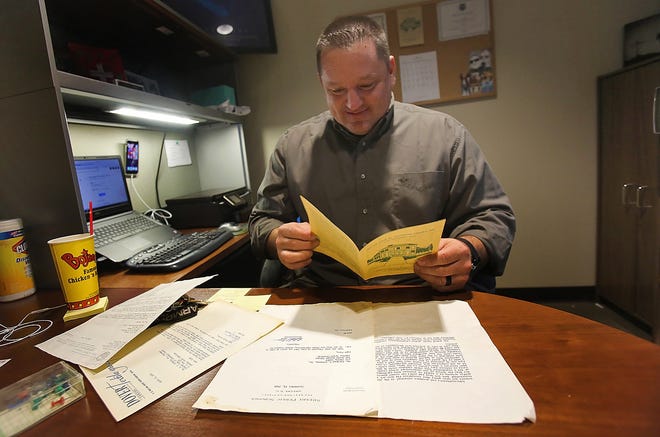 Chuck Barbee, director of Residential Services at Children's Homes of Cleveland County, looks through old letters and pamplets he found while preparing to move to a new building on Gidney Street in Shelby. [Brittany Randolph/The Star]