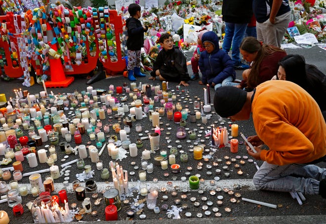 Students light candles as they gather for a vigil to commemorate victims of Friday's shooting, outside the Al Noor mosque in Christchurch, New Zealand, Monday, March 18, 2019. Three days after Friday's attack, New Zealand's deadliest shooting in modern history, relatives were anxiously waiting for word on when they can bury their loved ones.(AP Photo/Vincent Yu)