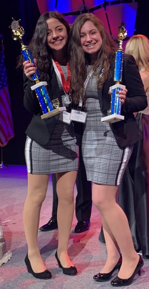 Somerset Berkley students Jaycey Tessier, left, and Emma Medeiros are pictured with the first-place trophies they won at the state DECA conference. [Submitted photo]