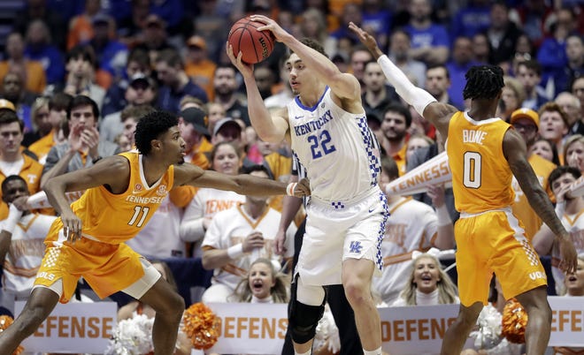 Kentucky forward Reid Travis (22) protects the ball from Tennessee defenders Kyle Alexander (11) and Jordan Bone (0) in the first half of an NCAA college basketball game at the Southeastern Conference tournament Saturday, March 16, 2019, in Nashville, Tenn. (AP Photo/Mark Humphrey)