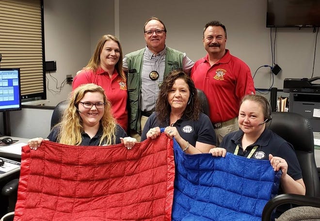The Lowcountry Firefighter Support Team donated "Operation Zzz" blankets to the Barnwell County 911 Dispatch Center on March 13. Pictured from left: (back row) Team member Andi Hogg, Barnwell County Chief Deputy Steve Griffith from the sheriff's office and Savannah River Region Coordinator Andy Hogg who is fire chief of the Long Branch Fire Department present two blankets to dispatchers (front row) Sierra Delk, Melinda Holcombe and Jennifer Padgett. [Contributed Photo]