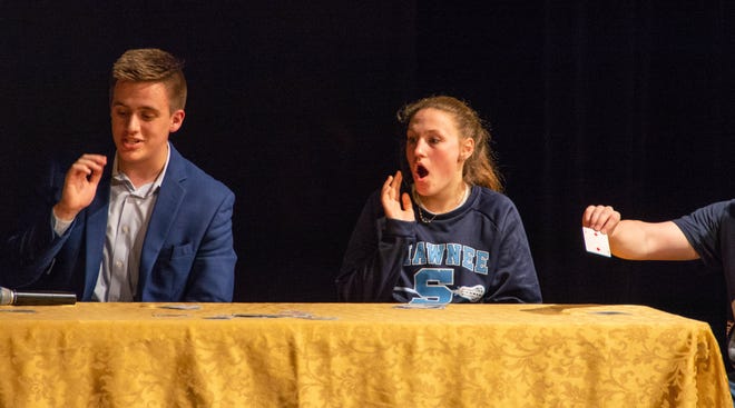 Shawnee senior Jake Strong performs a magic trick on stage with a member of the audience. [COURTESY OF MADELINE GIQUINTO]