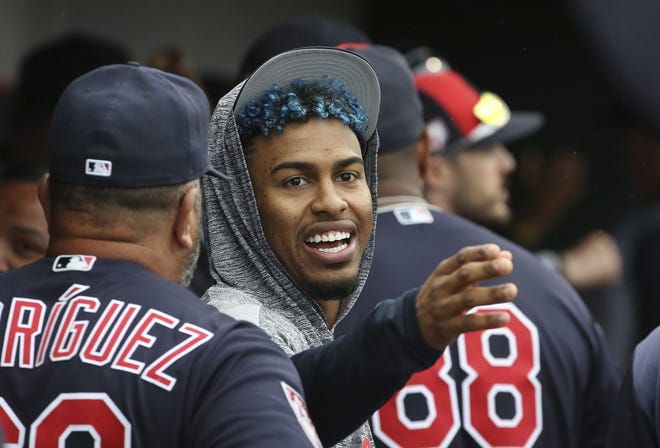 Injured Cleveland Indians shortstop Francisco Lindor talks to a teammate in the dugout during a spring training game on March 11 in Goodyear, Ariz. [AP Photo/Ross D. Franklin, File]