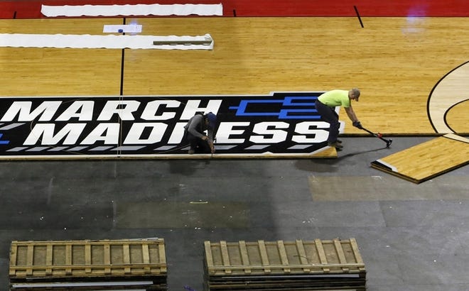 Workers prepare the floor at Nationwide Arena for the NCAA Tournament. [ERIC ALBRECHT/COLUMBUS DISPATCH]