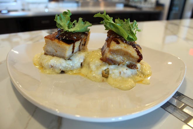 Pork Belly, on the lunch menu, is topped with fig preserves and served over fried green tomatoes smothered in Gouda grits. [PHOTOS BY JAN WADDY/THE NEWS HERALD]