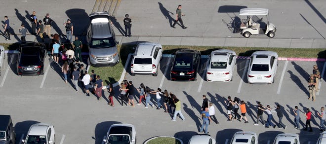 Students are evacuated by police out of Stoneman Douglas High School in Parkland, Fla., after a shooting on Wednesday, Feb. 14, 2018. (Mike Stocker/Sun Sentinel/TNS)