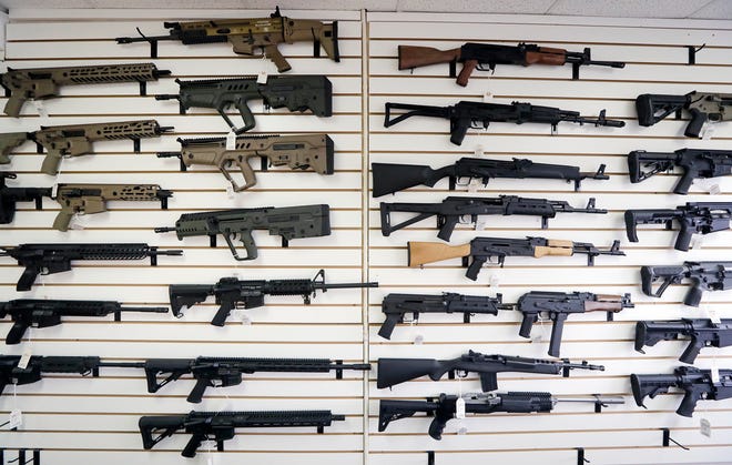 Semiautomatic rifles fill a wall at a gun shop in Lynnwood, Wash. [AP Photo/Elaine Thompson]