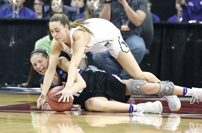 Kansas State guard Kayla Goth, bottom, battles Michigan guard Amy Dilk for possession of the ball during the second half of a first-round game in the NCAA women's college basketball tournament Friday in Louisville, Ky. [Timothy D. Easley/The Associated Press]