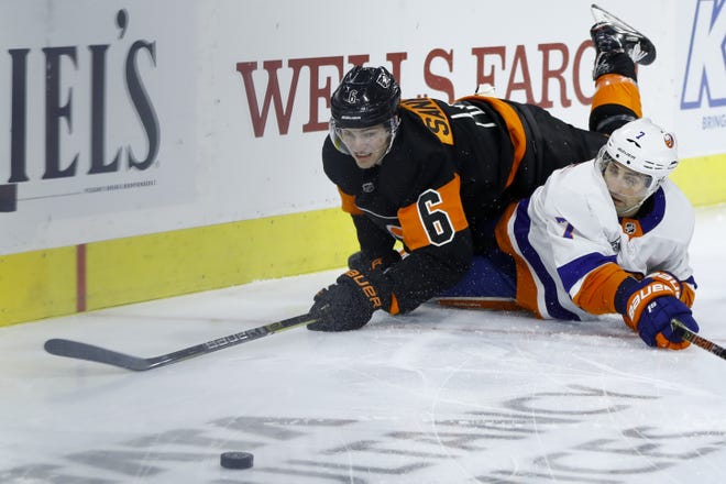The Flyers' Travis Sanheim and the Islanders' Jordan Eberle battle for the puck from the ice during Saturday's game. [MATT SLOCUM / ASSOCIATED PRESS]