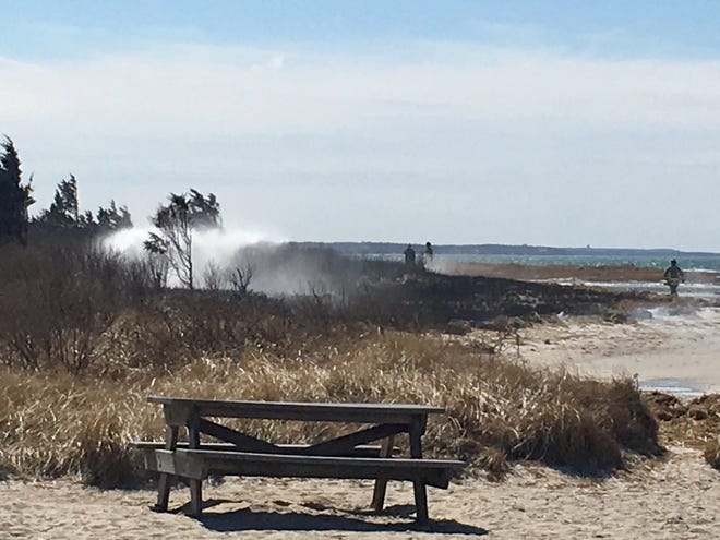 Firefighters were dousing a brush fire Sunday afternoon west of Rock Harbor in Orleans. [Patrick Cassidy/Cape Cod Times]