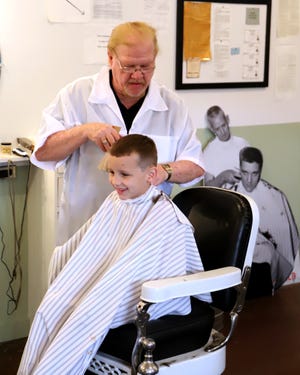 Luke Shaw gets his "G.I. buzzcut" from barber Jimmy Don Peterson on Saturday, March 23, 2019, during the 60th anniversary celebration of Elvis Presley's legendary haircut at Fort Chaffee at the Chaffee Barbershop Musuem in the historic district at Chaffee Crossing. Peterson is the son of Elvis' Army barber, James B. Peterson, and provided the cuts as well as sharing stories from his father's time at the camp. [JAMIE MITCHELL/TIMES RECORD]