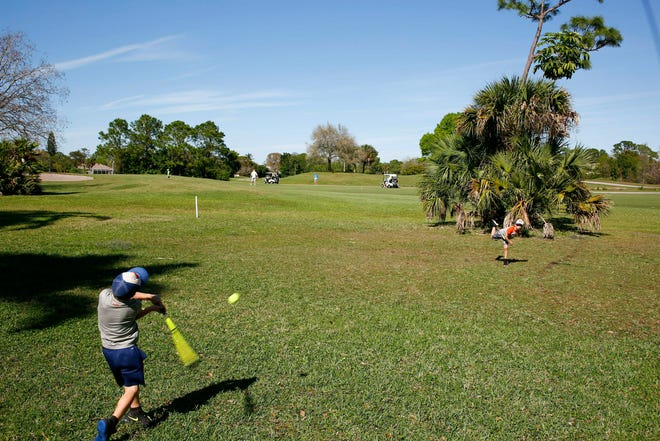 Ripken Sullivan, 8, right, and his brother Brooks, 6, play baseball in their backyard along the Bardmoor Golf Course Thursday, Feb. 28, 2019 in Seminole, Fla. Residents of Bardmoor, an upscale mid-Pinellas community, are outraged about plans to sell the golf course and redevelop it into scores of new homes. (Luis Santana/Tampa Bay Times via AP)