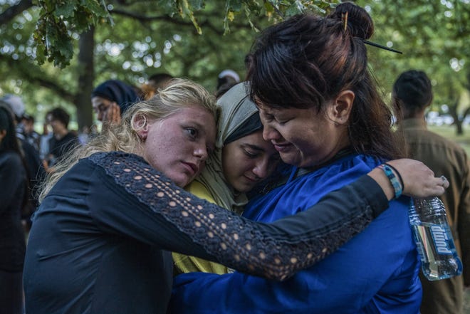 People gather at a community-led vigil in tribute to victims near Al Noor Mosque in Christchurch, New Zealand, last week. As the first six victims of the Christchurch mosque shootings were laid to rest Wednesday, some affected families were still waiting to learn the fate of their loved ones. (Adam Dean/The New York Times)