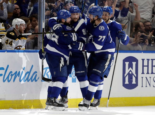 Tampa Bay's Nikita Kucherov, left, celebrates his game-tying goal in the third period with teammates Victor Hedman (77) and Steven Stamkos (91) during Monday's 5-4 win over Boston.