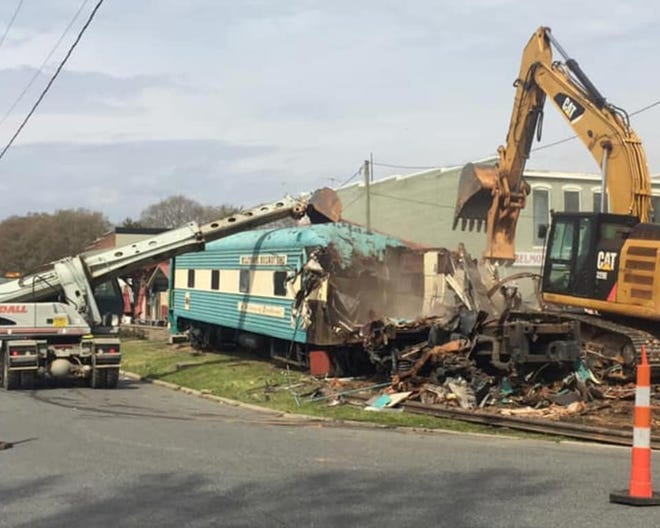 Crews demolish the old train car near the historic train depot on Glenway Avenue in Belmont on Monday. [LEE EDWARDSEN/SPECIAL TO THE GASTON GAZETTE]