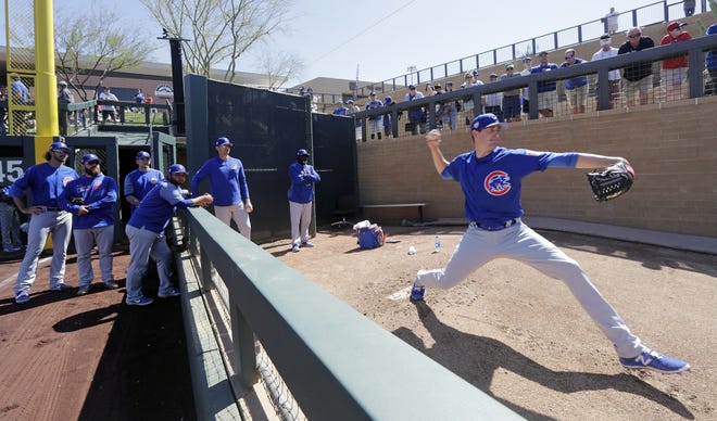 Teammates and coaches watch as Chicago Cubs starting pitcher Kyle Hendricks warms up in the bullpen before the team's spring training game against the Arizona Diamondbacks on Saturday, March 16, 2019, in Scottsdale, Ariz. [ELAINE THOMPSON/THE ASSOCIATED PRESS]