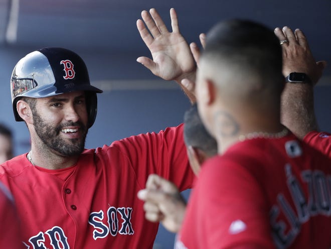 J.D. Martinez celebrates with his teammates in the dugout after scoring a run during a spring training game in West Palm Beach, Fla., this month. Martinez hit .330 with 43 home runs and a league-best 130 RBI last season. [Brynn Anderson/AP]