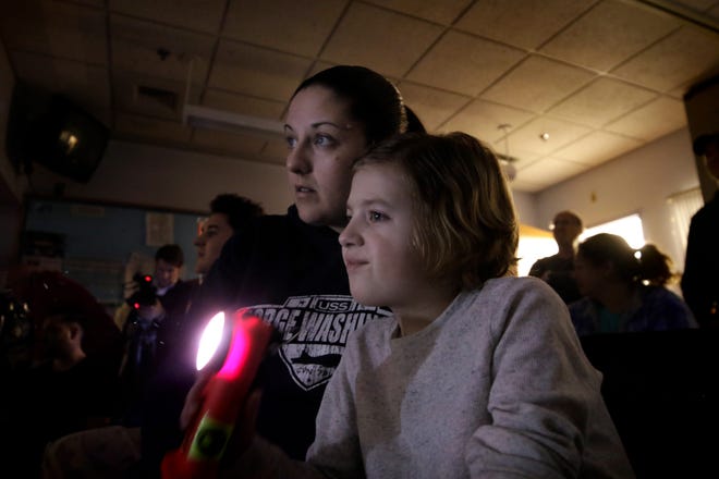 Gavin Anderson and his mom Carol look out from a darkened room at Hasbro Children's Hospital on Wednesday evening to view the lights flashing from outside as part of the Good Night Lights program. The program began three-and-a-half years ago to buoy the spirits of the young patients at Hasbro. [The Providence Journal / Kris Craig]