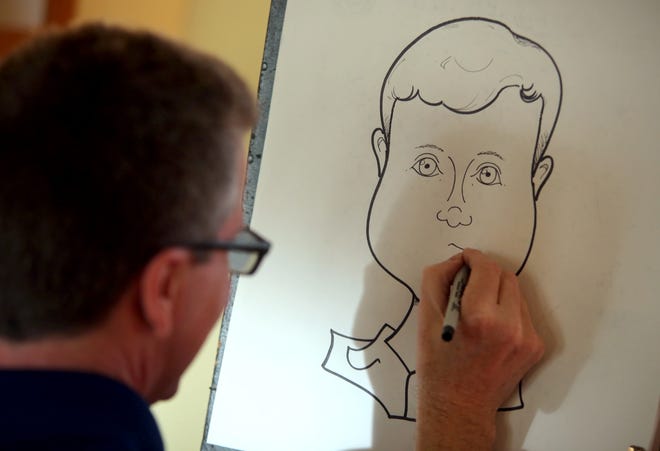 Andrew Poston works on a caricature at the Comic Stripped exhibit opening on Friday. [Brittany Randolph/The Star]