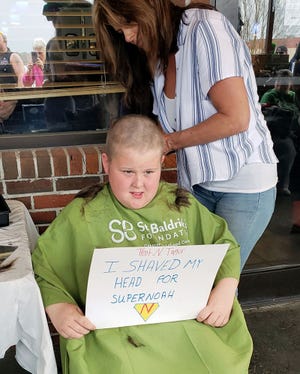 Nine-year-old Trent Taylor, a fourth grader at Contentnea-Savannah K-8 School, has his head shaved Monday during the St. Baldrick’s Foundation fundraiser for childhood cancer research. One of the youngest and among the top fundraisers in the Lenoir County event, Trent has participated for four of the last five years, moved to help by the death of the infant son of a family friend.