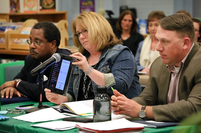 Julie Cochrane plays a recording of her daughter crying and asking not to go to school during a hearing with the Hampton School Board. At far left is Rogers Johnson, president of the Seacoast NAACP.

[Ioanna Raptis/Seacoastonline]