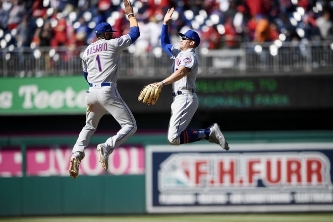 The New York Mets' Amed Rosario, left, and Brandon Nimmo celebrate after a beating the Washington Nationals 2-0 on Thursday during their season opener in Washington. [Nick Wass/The Associated Press]