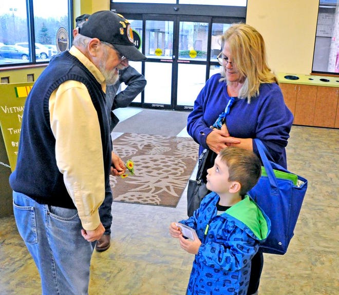 Wayne LeLear hands Emmett Thompson a star from a flag as Thompson was with his grandmother, Jen Cramlett, shopping at Buehler's Milltown. LeLear is a member of the Barry Caruso Chapter Number 255 of the Vietnam Veterans of America group. Members of the organization were at the Wooster store Friday providing educational material about the Vietnam War and distributing flag tokens and the special Vietnam War Memorial Poppy for National Vietnam War Veterans Day on Friday. In 2017, President Donald Trump signed into law The Vietnam War Veterans Recognition Act of 2017, designating every March 29 as National Vietnam War Veterans Day.