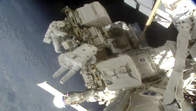 Astronauts Nick Hague and Christina Koch float outside the International Space Station on Friday, a week after the first spacewalk to install new and stronger batteries for the station's solar power grid. Koch was supposed to go out with Anne McClain, but there weren't enough medium suits readily available. So the first all-female spacewalk had to be scrapped. [NASA via AP]