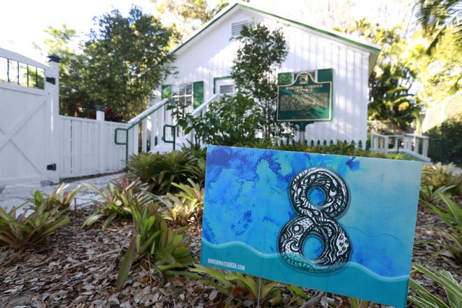 A yard sign stating that the area is 8 feet above sea level is shown in front of artist Xavier Cortada's studio in Pinecrest. [AP Photo/Wilfredo Lee]