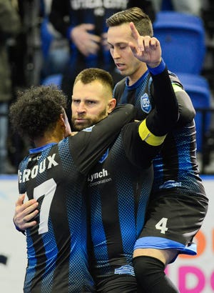 Utica City FC's Bo Jelovac, center, celebrates a goal with teammates Stephen Deroux (77) and Nate Bourdeau (4) during Saturday's game against the Mississauga MetroStars at the Adirondack Bank Center at the Utica Memorial Auditorium. [ALEX COOPER / OBSERVER-DISPATCH]