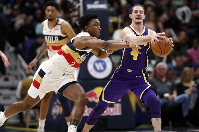 Los Angeles Lakers guard Alex Caruso (4) and New Orleans Pelicans forward Stanley Johnson (3) during the second half of Sunday's game in New Orleans. The Lakers won 130-102. [Tyler Kaufman/AP Photo]