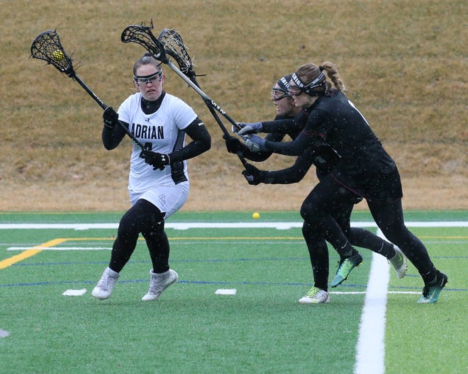 Adrian College attacker Annie Rice (4) looks to pass as two Calvin defenders close in during Saturday's Michigan Intercollegiate Athletic Association contest. Rice scored a goal and added two assists in the Bulldogs 16-5 loss.