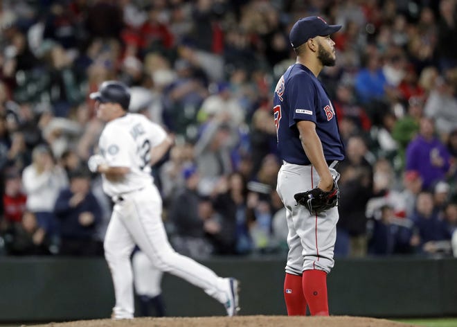 Boston Red Sox starting pitcher Eduardo Rodriguez (right) looks away as Seattle Mariners' Jay Bruce rounds the bases behind on his three-run home run in the fifth inning of Saturday's game in Seattle. [AP Photo/Elaine Thompson]