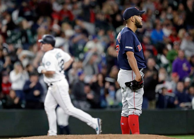 Boston Red Sox starting pitcher Eduardo Rodriguez looks away as the Seattle Mariners' Jay Bruce rounds the bases on his three-run homer in the fifth inning Saturday night in Seattle.