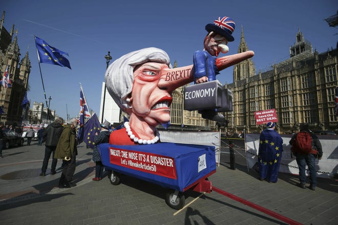 Anti-Brexit demonstrators with an effigy of British Prime Minister Theresa May near College Green at the Houses of Parliament in London, Monday. Britain's Parliament gets another chance Monday to offer a way forward on Britain's stalled divorce from the European Union, holding a series of votes on Brexit alternatives in an attempt to find the elusive idea that can command a majority. [Jonathan Brady/AP Photo]