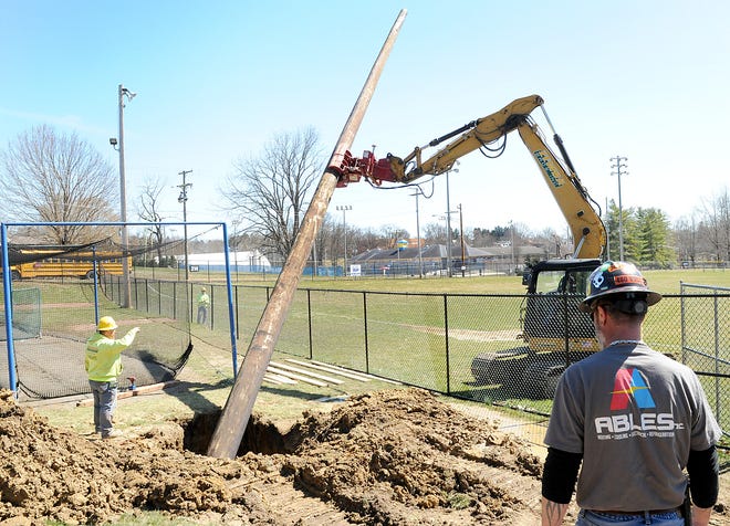 Workers from Zemba Bros. carefully set a new 65-foot-tall light pole at Don Coss Field last week. The old pole was blown over during a windstorm last year. Ables Inc. was planning to attach eight new metal halide lights on it.