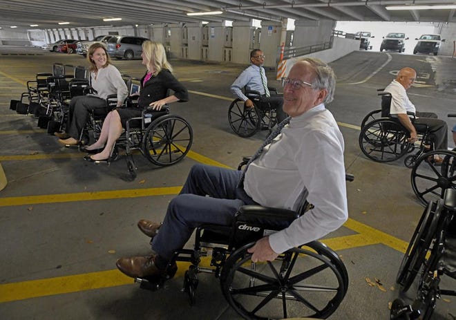 Lakeland Mayor Bill Mutz and other city officials participate in the "handicap challenge" to understand mobility issues for wheelchair users.