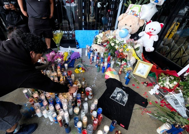 Fans of rapper Nipsey Hussle appear at a makeshift memorial in the parking lot of Hussle's Marathon Clothing store in Los Angeles on Monday. Hussle was killed in a shooting outside the clothing store on Sunday.