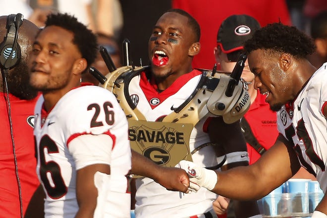Georgia defensive back J.R. Reed (20) celebrates after getting to put on the golden spikes after making an interception on a fourth down during the game last season at South Carolina. [JOSHUA L. JONES/ATHENS BANNER-HERALD]