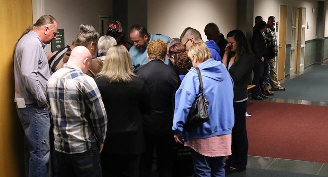 Friends and family members of Mark Carver pray together in the hallway outside courtroom 4D Tuesday morning, April 2, 2019, at the Gaston County Courthouse. [Mike Hensdill/The Gaston Gazette]