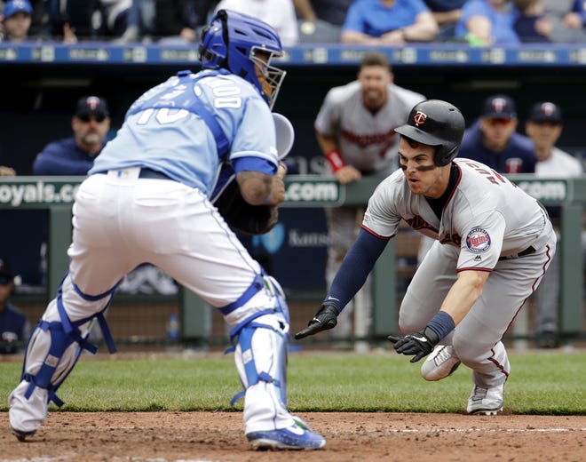 Tyler Austin of the Minnesota Twins beats the tag at home by Kansas City Royals catcher Martin Maldonado to score on a single by Max Kepler during the eighth inning of a baseball game Wednesday in Kansas City, Mo. [Charlie Riedel/The Associated Press]