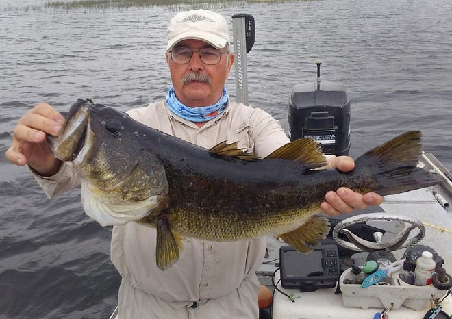 Monte Reder of Miles City, Montana, shows off a 10-pound largemouth bass he caught on a live shiner at Crooked Lake while fishing with Jim Childress of Big Bass Guide Service of Frostproof recently. (Provided by: Jim Childress of Big Bass Bait & Tackle)